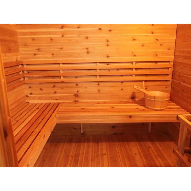 SunRay Denali HL400DS Outdoor Home Sauna - interior view of the sauna benches with bucket on the bench to the right. A slight view of the sauna heater to the very bottom right.