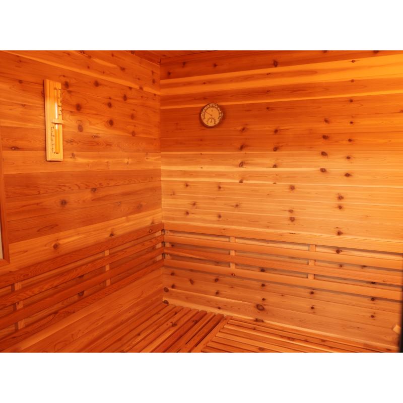 SunRay Denali HL400DS Outdoor Home Sauna - interior view of the corner where the side wall meets the back wall on the left. Hygrometer on the wall in the top center of the picture and the thermometer on the wall to the top left.