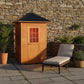 Sunray Eagle 200D1 Outdoor Traditional Steam Sauna - on a backyard patio beside a stone wall, with a lounge chair in front