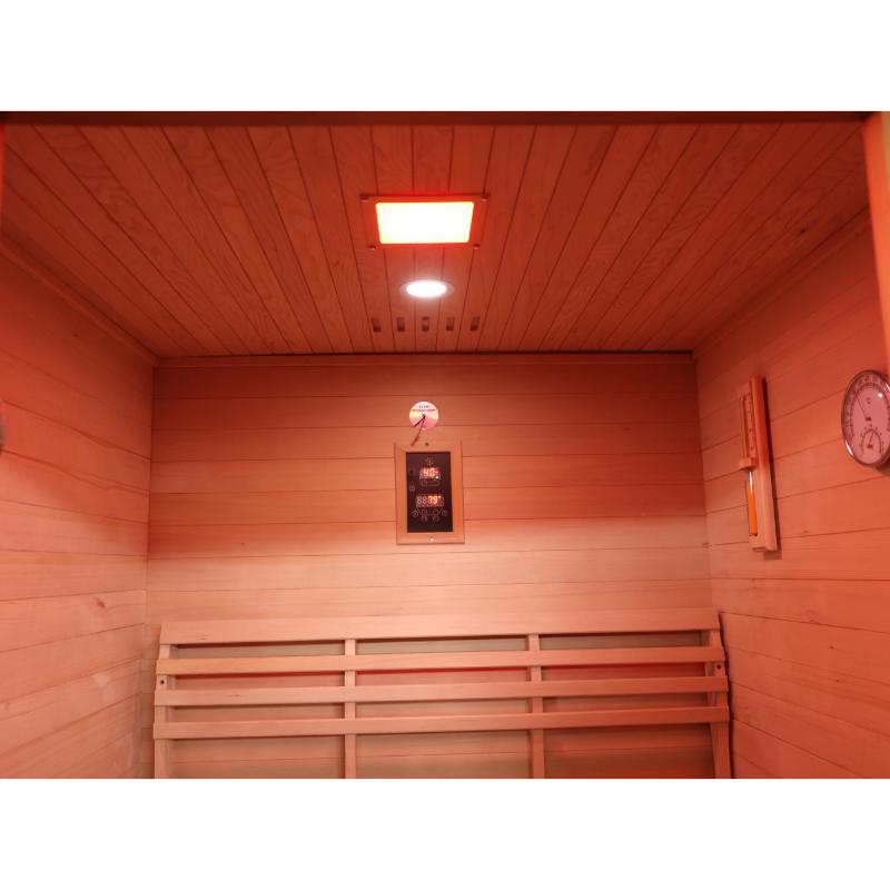 Sunray Freeport 300D1 Outdoor Traditional Steam Sauna - view of the interior wood ceiling and walls with the ceiling light at the top, control panel on the back wall and the sand timer and hygrometer on the wall to the right.