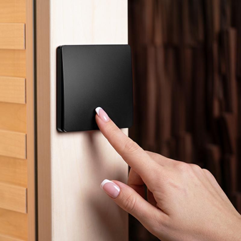 Single zone lighting kit - a hand pressing the wall button for the light