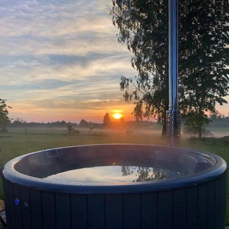 Wood-Fired Hot Tub S4N - close up of the tub, view of the water inside, open field and sunset in the background