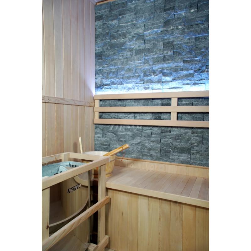 Westlake 3 Person Traditional Sauna - interior view of Harvia heater on the left and rock wall with bench backrest backlighting.