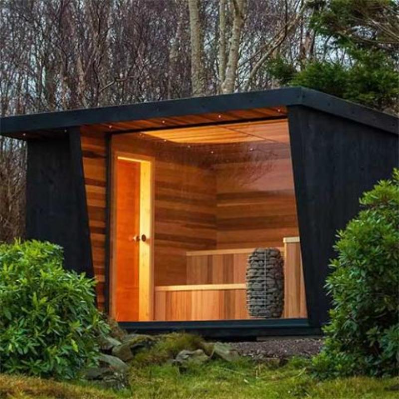 HIVE Mini Series 10.5kW Sauna Heater - outside view of a sauna cabin with a glass wall showing the sauna heater beside benches