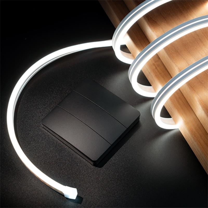 White LED strip light on a black surface with a wooden block