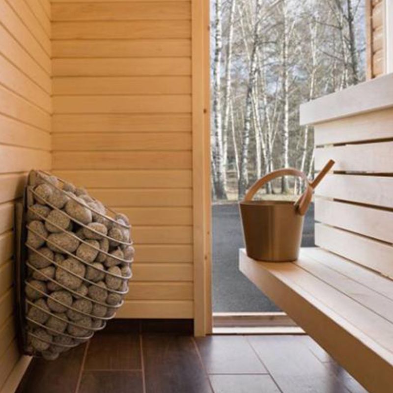 HUUM Drop sauna heater mounted on a wall inside of a sauna